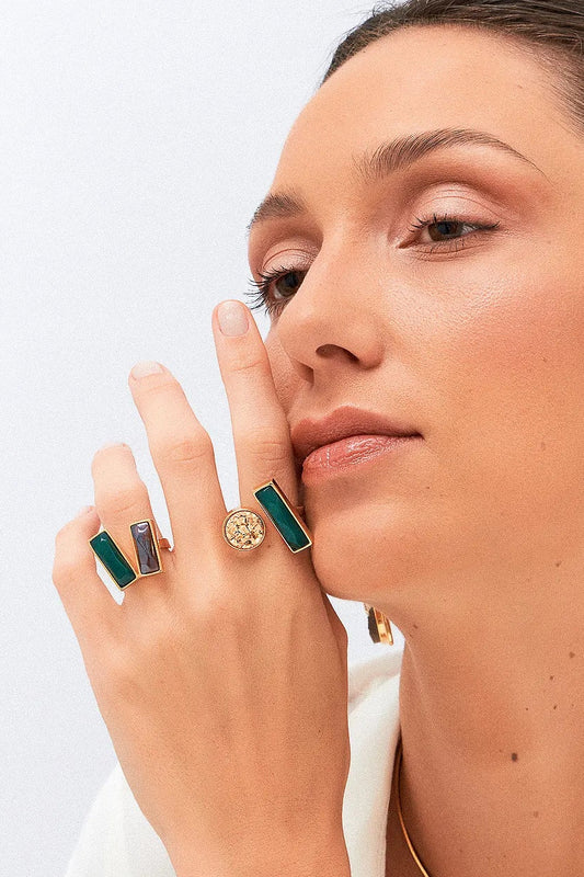 O Anel Harmonie - Ágata Verde e Quartzo Fumê, da Coleção Convicta, é uma joia projetada para a mulher moderna e multifacetada. Esta peça com banho de Ouro 18K e lapidação multifacetada une a vitalidade da Ágata Verde e a proteção do Quartzo Fumê. O anel é ideal para quem busca acessórios que combinem estilo sofisticado com bem-estar, ajudando a restaurar a força interior e neutralizar vibrações negativas.