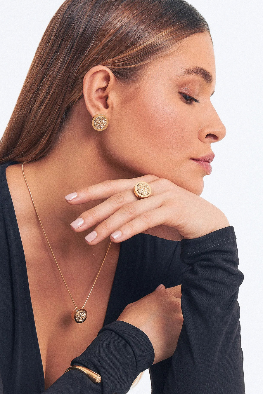 Modelo de olhos fechados usando brincos, colar e anel com Drusa Ouro, banhados a ouro 18k