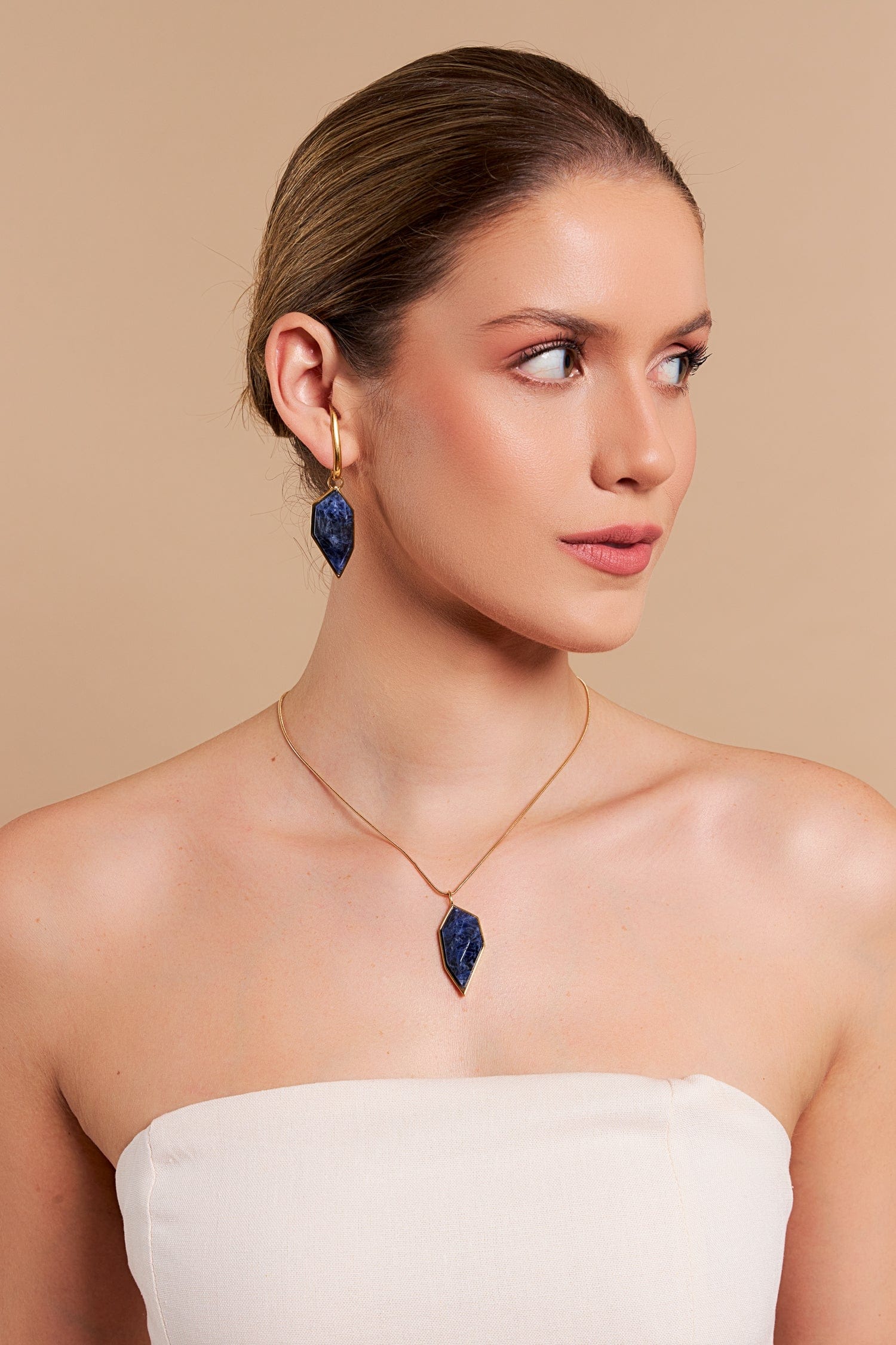 Brinco Impulso com Sodalita Azul – Design exclusivo em ouro 18k que simboliza paixão e autenticidade.