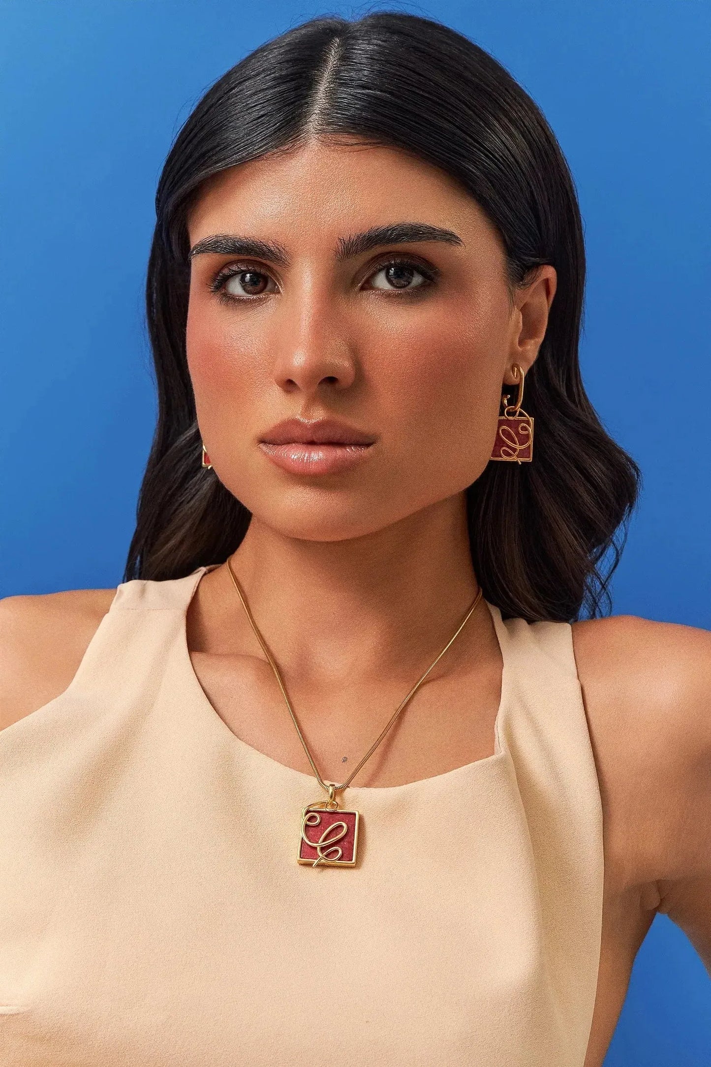 O Colar Forma com Feldspato Vermelho em Banho de Ouro 18K traduz o ponto em que o traço ganha direção. A pedra quadrada de Feldspato Vermelho, que simboliza vitalidade e paixão, recebe a aplicação de linhas em metal que se cruzam, criando uma linguagem super contemporânea. Com sua corrente robusta, é uma peça moderna e sofisticada, ideal para quem busca energia e força de vontade.